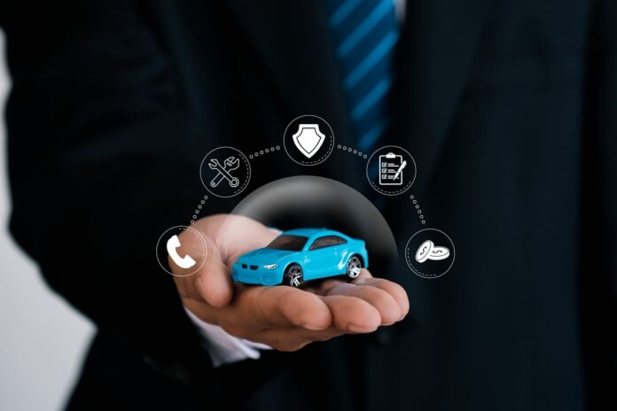 Kaskokindlustuse kontroll - helesinine mudelauto mehe peopesas ja kindlustuskaitsete ikoonidega mulli all