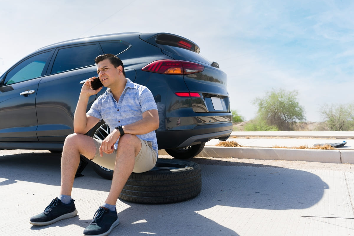 Kaskokindlustus transiitnumbriga autole - mees auto kõrval istumas ja helistamas