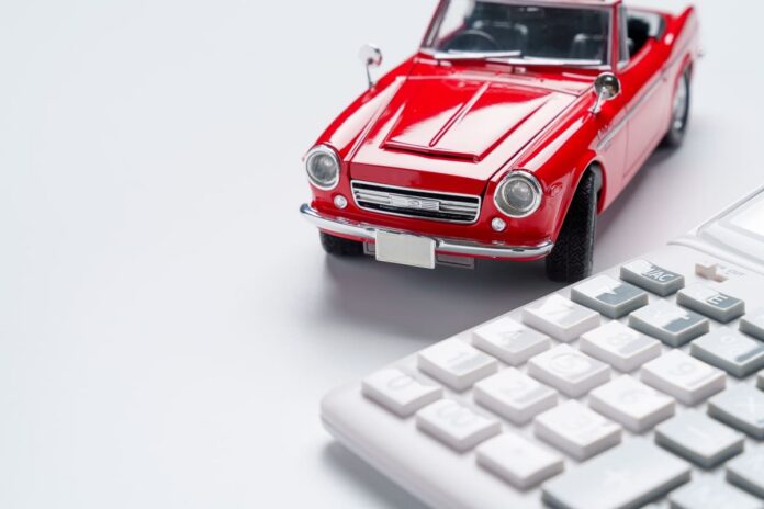 Kaskokindlustus vanemale autole - vana punane mudelauto valgel kalkulaatoril