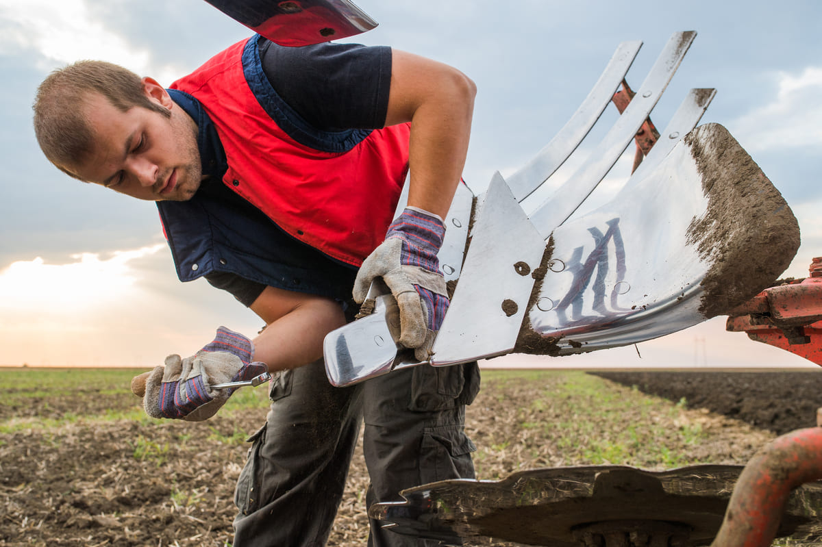 Haakeseadme kaskokindlustus - põllumees remondib haakeseadet