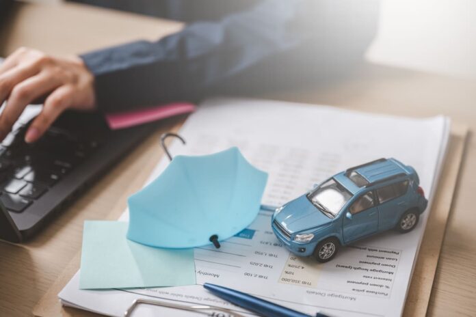 Alakindlustus kaskos - sinine mudelauto laual, sinine vihmavari tema kõrval, mitte teda kaitsmas