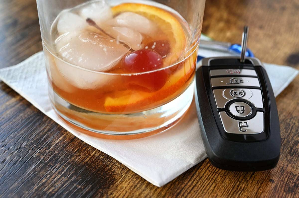 Kaskokindlustuse koguriskikindlustus - klaas pruuni joogi ja jääkuubikutega ning autovõtmed